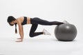 Young sportswoman doing basic plank exercise with fitness ball Royalty Free Stock Photo