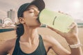 Young sportswoman drinks water after jogging. Fitness concept