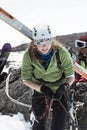 Young sportswoman ski mountaineer climbing on rope on rock