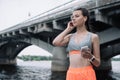 young sportswoman with smartphone earphones