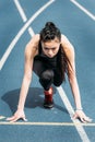 Young sportswoman in starting position on running track stadium Royalty Free Stock Photo