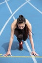 Young sportswoman in starting position on running track stadium Royalty Free Stock Photo