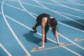 Young sportswoman in starting position on running track stadium Royalty Free Stock Photo