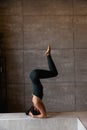 Young sporty attractive woman practicing yoga, doing headstand exercise Royalty Free Stock Photo