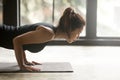 Young attractive woman in chaturanga dandasana pose, studio, sid