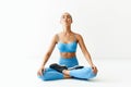 Young sporty attractive woman in sportswear practicing yoga, meditating in Lotus pose Padmasana Royalty Free Stock Photo