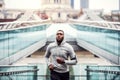 Young sporty black man runner running on the bridge outside in a city. Royalty Free Stock Photo