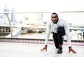 Young sporty black man runner in starting position on the bridge in a city. Royalty Free Stock Photo