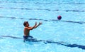 Young sporty boy playing ball in big outdoor swimming-pool Royalty Free Stock Photo