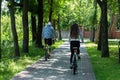 Young sporty couple riding on mountain bicycle on the road. Back view