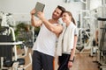 Young sporty couple taking selfie with tablet device.