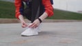 Young sporty female tying shoe lace and strating running