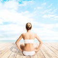 Young, sporty and beautiful girl meditating on a pier at summer. Yoga concept. Royalty Free Stock Photo