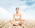 Sporty, young and beautiful woman in swimsuit meditating on a pier at summer. Sport and yoga concept. Royalty Free Stock Photo