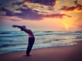 Young sporty fit woman doing yoga Sun salutation Surya Namaskar