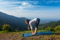 Young sporty fit woman doing yoga Sun salutation Surya Namaskar