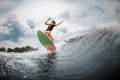 Young girl jumps on a wakeboard in the river near forest Royalty Free Stock Photo