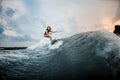 Young girl riding on a wakeboard in the river near forest Royalty Free Stock Photo