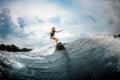 Young girl surfs on a wakeboard in the river near forest Royalty Free Stock Photo