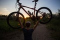 A young sporty man is holding a bicycle at sunset Royalty Free Stock Photo