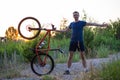 A young sporty man is holding a bicycle at sunset Royalty Free Stock Photo