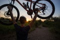 A young sporty man is holding a bicycle at sunset Royalty Free Stock Photo