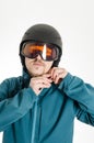 Man with goggles putting on ski helmet