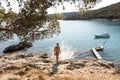 Young sporty man wearing red speedos tanning and realaxing on wild cove of Adriatic sea on a beach in shade of pine tree Royalty Free Stock Photo