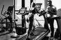 Young sporty sexy couple workout cardio exercise gym. Sportive couple in gym. Personal trainer helping woman doing Royalty Free Stock Photo