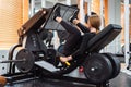 Young sporty woman does leg exercises on leg press machine Royalty Free Stock Photo