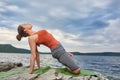 Young sporty woman doing different variants of yoga position on a rocky rivershore. Royalty Free Stock Photo