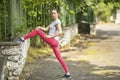 Young sporty woman doing exercise stretching and warm-up before Jogging in park in sunshine on beautiful summer day Royalty Free Stock Photo