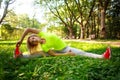 Young sporty woman doing fitness exercises stretching in park Royalty Free Stock Photo