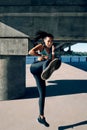 Young sporty woman doing high kick outdoors Royalty Free Stock Photo