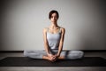 Young sporty woman doing yoga stretching exercise sitting in gym near bright windows Royalty Free Stock Photo