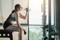 Young sporty woman drinking water after working out in the gym. Royalty Free Stock Photo