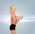 Young sporty woman with heavy steel dumbbell