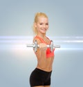 Young sporty woman with heavy steel dumbbell