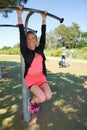 Young sporty woman make sport fitness exercises on street playground pull-ups bar outdoor at fun activity workout and fitness park Royalty Free Stock Photo