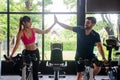 Young sporty woman and man giving each other a high five after cycling training in gym. Fit couple high five after workout Royalty Free Stock Photo