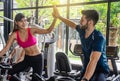 Young sporty woman and man giving each other a high five after cycling training in gym. Fit couple high five after workout in Royalty Free Stock Photo