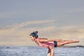 Young sporty woman practicing acroyoga exercises at sunrise or sunset.