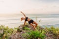 Attractive woman doing yoga in outdoor at sunset and ocean on background Royalty Free Stock Photo