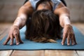 Young sporty woman practicing yoga, doing Balasana exercise, clo