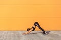 Young sporty woman practicing yoga, doing downward facing dog exercise, adho mukha svanasana pose, working out, wearing black Royalty Free Stock Photo