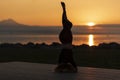 Young sporty woman practicing yoga, doing headstand exercise