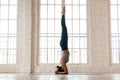 Young sporty woman practicing yoga, doing headstand exercise Royalty Free Stock Photo