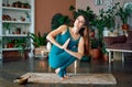 Young sporty woman practicing yoga at home doing prayer twist pose Royalty Free Stock Photo