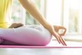 Young sporty woman practicing yoga lesson sitting in Sukhasana exercise, Easy Seat pose with mudra gesture, working out. Royalty Free Stock Photo