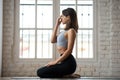 Young sporty woman practicing yoga, nadi shodhana pranayama pose